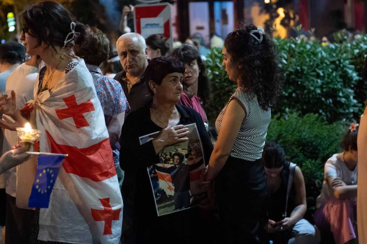 Devidze’s grandmother holds a portrait of her grandson besides his sister, at a protest following the verdict. Photo: Mariam Nikuradze/OC Media.